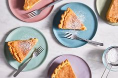 four plates with different types of pie on them and one has a fork in it