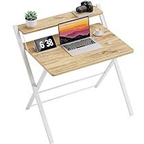 a laptop computer sitting on top of a wooden desk next to a phone and plant