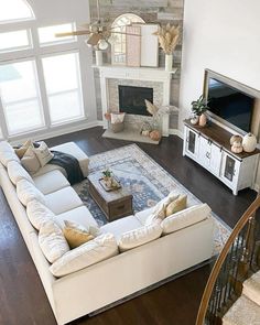 a living room filled with furniture and a flat screen tv on top of a wooden floor