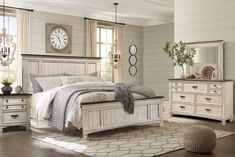 a white bed sitting in a bedroom on top of a hard wood floor next to a window