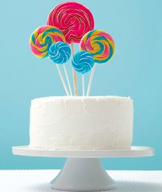 colorful lollipops on top of a white cake