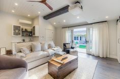 a living room filled with furniture and a ceiling fan