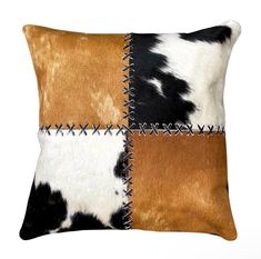 a brown and black cowhide pillow with stitching on the front, side and back