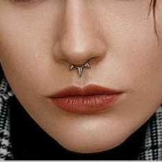 a woman's nose with two piercings on top of her nose and the bottom part of her nose