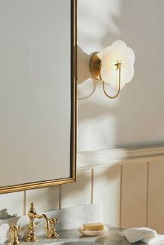 a bathroom sink with a mirror and lights on the wall next to it's counter