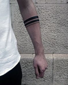 a person with a wrist tattoo on their left arm and one hand holding the other