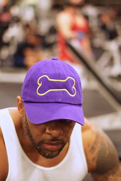 a man wearing a purple hat with a yellow dog bone on the front and side