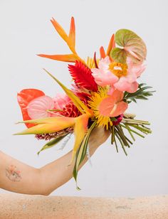 a woman's arm holding a bouquet of flowers