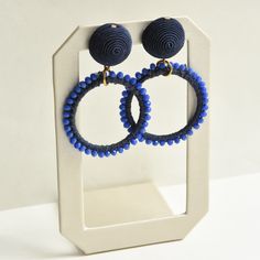 Blue Beaded Loop Earrings - Goldmakers Fine Jewelry Blue Handwoven Dangle Jewelry, Blue Large Beads Drop Earrings, Blue Large Beaded Drop Earrings, Blue Beaded Drop Earrings With Large Beads, Adjustable Blue Earrings With Large Beads, Handmade Blue Bohemian Clip-on Earrings, Elegant Woven Dangle Jewelry, Blue Handmade Dangle Clip-on Earrings, Handmade Blue Round Clip-on Earrings