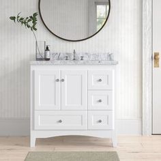 a white bathroom vanity with a round mirror above it and a rug on the floor