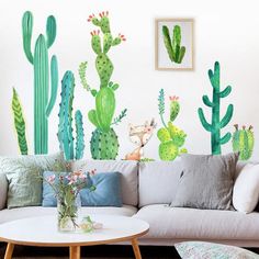 a living room filled with furniture and lots of cactus wall decals on the walls