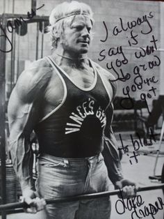 an autographed photo of a man holding a barbell in front of his face