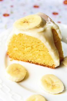 a piece of cake on a plate with banana slices around it and frosting in the middle