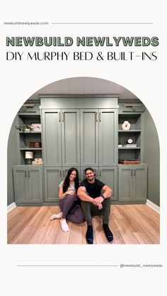 a man and woman are sitting on the floor in front of some green cupboards