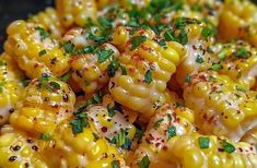 corn on the cob with parsley and pepper sprinkled on top, ready to be eaten