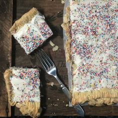 a piece of cake with sprinkles and a fork on a wooden table