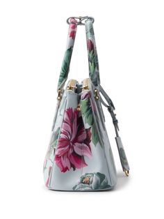 Find PRADA Saffiano Leather Handbag on Editorialist. This Prada handbag is crafted from Saffiano leather and features an all-over floral print. It has two rolled top handles, an adjustable handle wrap, and an adjustable detachable shoulder strap. The bag opens at the top and has two zip-fastening compartments. The main compartment features an internal zip-fastening pocket and an internal logo plaque. The bag is fully lined and has gold-tone hardware. Luxury Floral Print Top Handle Bag, Designer Leather Bag With Floral Print, Leather Top Handle Bag With Floral Print, Elegant Leather Shoulder Bag With Floral Print, Elegant Floral Print Top Handle Shoulder Bag, Elegant Top Handle Bag With Floral Print, Prada Handbag, Prada Saffiano, Prada Handbags