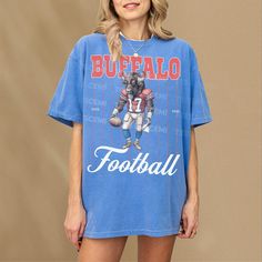 This retro Buffalo football t-shirt features a vintage illustration of a Buffalo holding a football dressed as a football player. This tee is the perfect gift for football fans or anybody who loves a good buffalo and football. This shirt is not associated with any team or league and is simply a piece of sports memorabilia for football fans in buffalo. This retro pinstripe football graphic t-shirt is an awesome piece of buffalo football merch for any sports fan or member of the mafia. This retro Football Season Sports Fan T-shirt With Screen Print, Sports Fan T-shirt For Football Season With Screen Print, Football Season Team Spirit Graphic T-shirt, Team Spirit Football Season Graphic T-shirt, Football Season Streetwear T-shirt With Text Print, Letter Print T-shirt For Football Season Streetwear, Blue T-shirt For Football Season, Blue Graphic Print Tops For Football Season, Football Season Fan Merchandise Graphic Tee