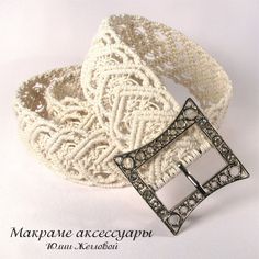 a white lace belt with a metal buckle on the front and side, decorated with filigrees