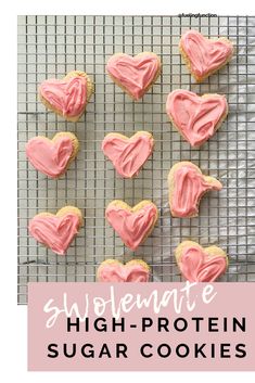 homemade high - protein sugar cookies with pink frosting in the shape of hearts on a cooling rack