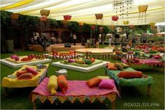 an outdoor event with lots of couches and pillows on the grass in front of them