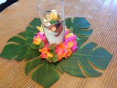 a glass filled with food sitting on top of a wooden table next to green leaves