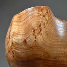 a wooden bowl that is made out of wood and has wavy lines on the surface