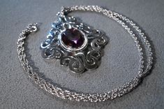 I am offering you this truly exquisite vintage silver tone designer signed Sarah Coventry large domed pendant charm, and necklace chain. there is also a r large oval shaped purple amethyst colored faceted glass stone set in the center of this fabulous pendant charm. Just look at the marvelous scrolled fancy design we have here ! This is such a fine example of the art deco era designs This I rarely see !! The design has a very elegant flair to it What a spectacular design So very regal. The penda Vintage Purple Oval Pendant Necklace, Fancy Design, Sarah Coventry, Art Deco Era, Faceted Glass, Coventry, Stone Pendant, Star Necklace, Link Necklace