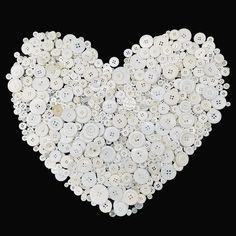 a heart made out of buttons on a black background