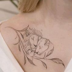 a woman with a lion and fish tattoo on her back shoulder is holding onto a branch