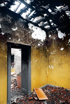 an open door in the middle of a room that is burnt and needs to be cleaned