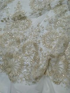 "This stunning Lace Fabric design piece has soft hand feel, It's perfect for weddings, bridal parties, and any events. Shop our large inventory of bridal fabrics. ☆PRODUCT DESCRIPTION : This gorgeous fabric is made on a sheer base with a beautiful vintage embroidery and delicate beaded throughout. The fabric width is approximately 51\" (130cm) Wide. Color: light champagne as in picture Material: Rayon, Polyester，Sequins, Pearls ☆ PURCHASING INFORMATION: This fabric is sold by the yard and each Q Glamorous Gold Embroidered Wedding Dress, Glamorous Fitted Tulle Fabric For Wedding, Gold Sequined Wedding Dress, Glamorous Lace Mother Of The Bride Dress With Sequins, Glamorous Gold Sequin Fabric For Banquets, Gold Sequin Fabric For Banquet, Glamorous Gold Sequin Fabric For Banquet, Elegant Cream Embroidered Fabric With Sequins, Gold Embroidered Fabric With Pearl For Wedding