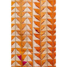 an orange and white wall hanging with several different designs on the outside, including leaves