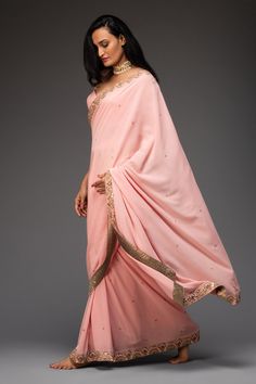 Pink saree highlighted with zardozi and mirror embroidery. Comes with cutout georgette blouse.
Components:2
Pattern:Embroidered
Type of Work:Floral
Neckline:Leaf
Sleeve Length:Sleeveless
Fabric:Georgette
Color:Pink
Other Details:
Cutout blouse
Occasion:Destination Wedding, Sangeet - Aza Fashions Designer Chinon Pre-draped Saree For Diwali, Eid Georgette Pre-draped Saree With Gota Work, Festive Pre-draped Saree With Gota Work, Bollywood Style Pre-draped Saree With Gota Work For Navratri, Traditional Gota Work Pre-draped Saree, Traditional Drape Saree With Mirror Work For Reception, Pre-draped Traditional Saree In Chinon, Bollywood Style Pre-draped Saree With Zari Work, Festival Designer Pre-draped Saree With Mirror Work