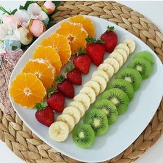 a white plate topped with sliced fruit and kiwis on top of each other