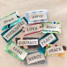 several pieces of fabric with words that say love, peace, and mercy on them