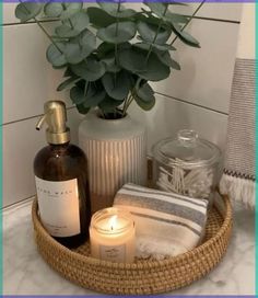 a basket filled with candles, soap and other items on top of a bathroom counter