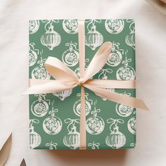 a present wrapped in green and white wrapping paper with a bow on top of it