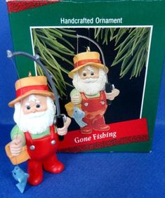 a christmas ornament with an image of two gnomes holding fishing rods and a fish