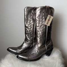 Sharon Western In Gunmetal Is A Handmade Women's Cowboy Boot Using Metallic Gunmetal Cowhide Leather Featuring A Fancy Black Western Stitch Pattern On Vamp, Heel Counter And Shaft. Black Calf Lining For A Sleek Finish. Made In Mexico From One Of The Largest Handmade Boots Factories In The World. Metallic Gunmetal Cowhide Leather Black Flame Stitch On Vamp, Shaft And Heel Counter Handmade For Us By Artisans At Old Gringo Black Lining 13" Height Round Toe 3" Fashion Heel Black Leather Sole Elegant Silver Snip Toe Boots, Silver Western Boots With Snip Toe, Metallic Pointed Toe Boots For Fall, Silver Leather Snip Toe Boots, Silver Boots With Reinforced Heel, Metallic Leather Boots With Round Toe, Silver Closed Toe Boots With Reinforced Heel, Silver Almond Toe Boots With Reinforced Heel, Silver Leather Western Boots