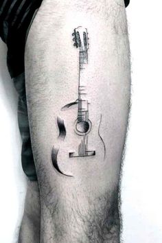 a man with a guitar tattoo on his leg