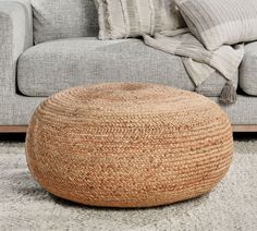 a living room with a gray couch and large round rug on the floor next to it