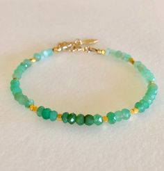 "Lovely natural green chrysoprase gemstone beaded bracelet with 24k gold vermeil accents. Beautiful Australian chrysoprase gems are 4mm faceted rondelles in luscious shades of light to darker apple green. 2mm faceted 24k solid gold vermeil cubes add sparkling accents. Made to order on professional beading wire with 14k gold fill spring ring clasp and findings. A little 22k gold vermeil leaf charm dangles from 1\" extension. Also available in .925 Sterling silver." Green Gemstone Rondelle Beaded Bracelets, Green Rondelle Beaded Spiritual Bracelets, Green Spiritual Rondelle Beaded Bracelets, Green Rondelle Bracelets With Faceted Beads, Green Onyx Beaded Bracelets As Gift, Green Rondelle Beaded Bracelets With Faceted Beads, Green Rondelle Bracelets For Jewelry Making, Green Jade Bracelets With Faceted Beads, Green Amazonite Round Bead Bracelets