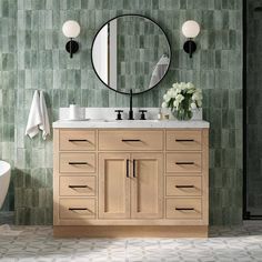 a bathroom with a sink, mirror and bathtub next to a wallpapered wall