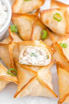 small appetizers are arranged on a white platter with dip in the middle