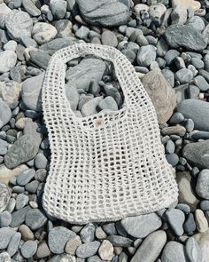 a white bag sitting on top of a pile of rocks