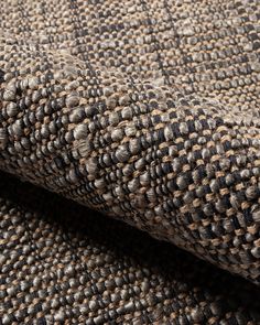 a close up view of a brown and black checkered tweed fabric with some small dots on it