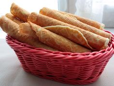 a basket filled with bread sticks sitting on top of a table