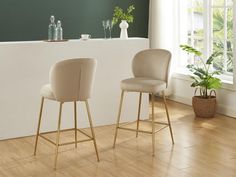 two beige chairs sitting next to each other on top of a hard wood floor