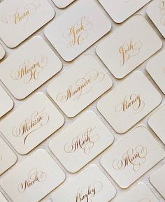 many white and gold business cards with names on them